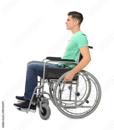 Young man in wheelchair on white background