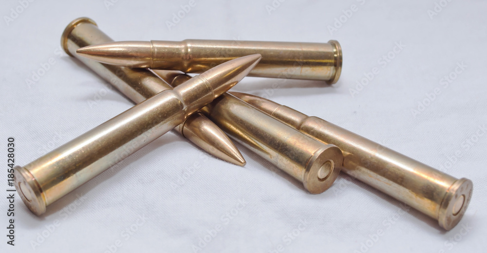 Several large caliber rifle bullets together on a white background Several large caliber rifle bullets together on a white background