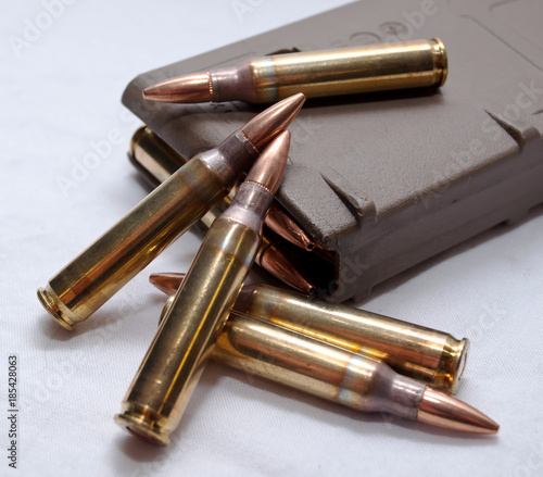 Several .223 caliber rounds and a loaded magazine on a white background