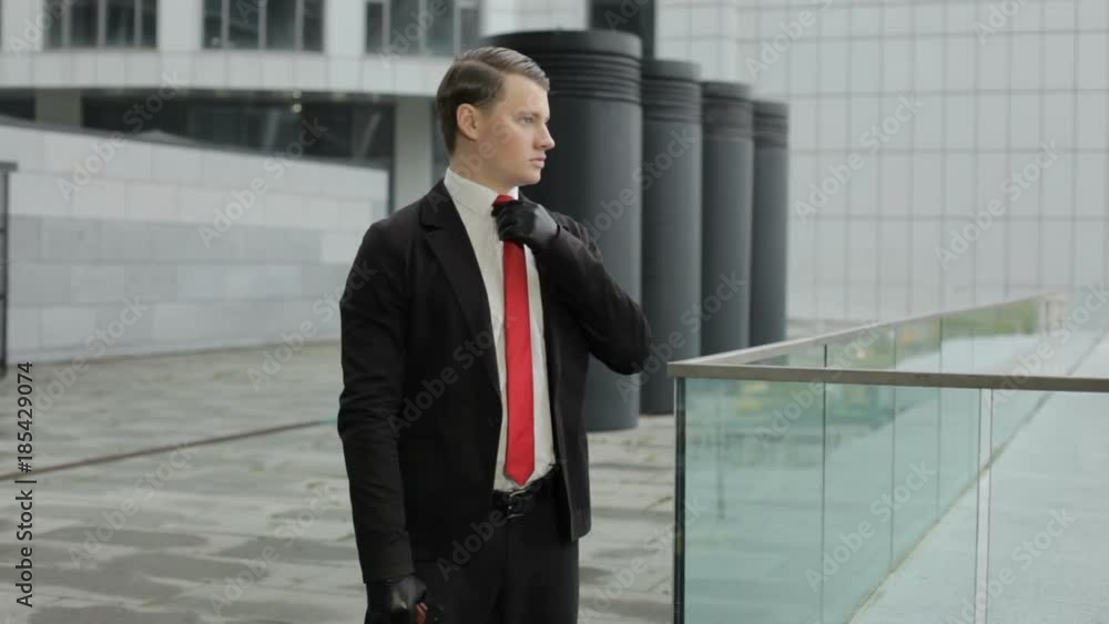 Man in a red tie shoots a pistol, he looks like a hired killer. Man in a red tie shoots a pistol, he looks like a hired killer.