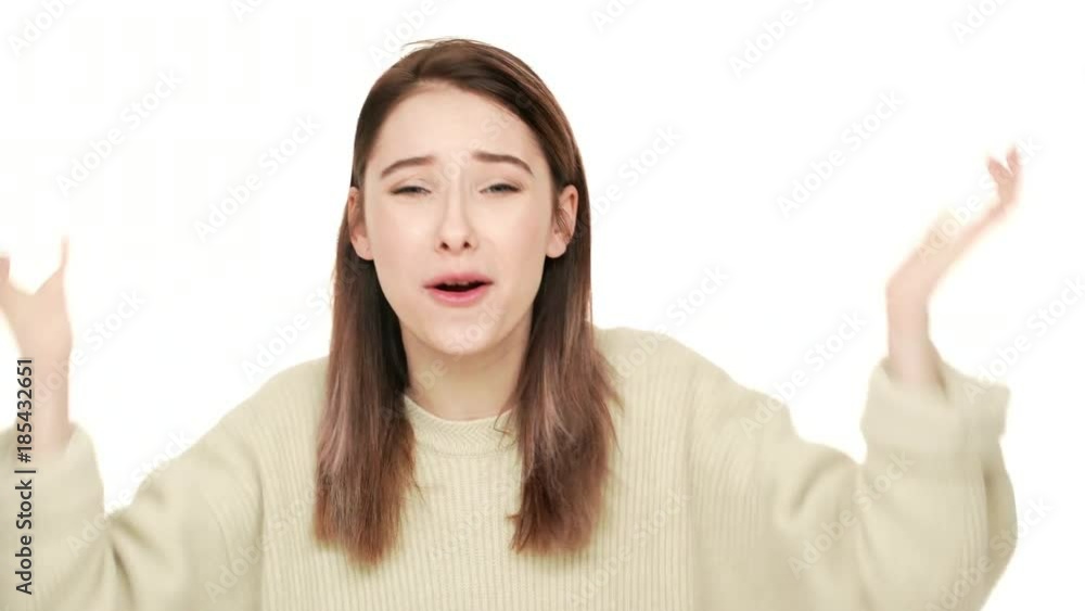 Studio portrait of annoyed long-haired woman in sweater gesturing in stress screaming asking why being angry over white background closeup. Concept of emotions Studio portrait of annoyed long-haired woman in sweater gesturing in stress screaming asking why being angry over white background closeup. Concept of emotions
