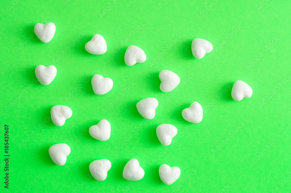 Valentine's Day. White polystyrene hearts on a green background