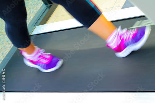 jogging to lose weight to be healthy,legs wearing sneakers running on treadmill.