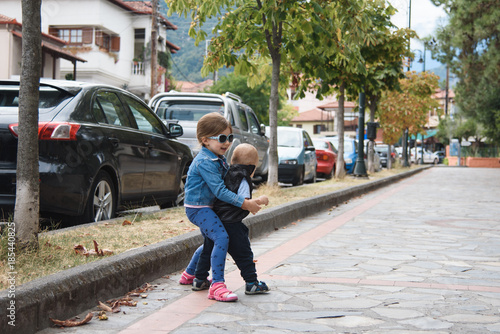 Sister Playing with Brother in Street