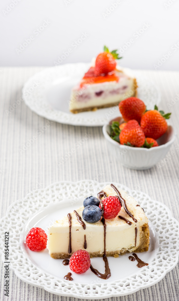 Delicious cheesecake with strawberry on a table against white wall. Delicious cheesecake with strawberry on a table against white wall.