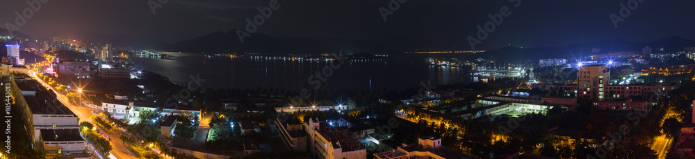 Panoramic city landscape at night, view of Dadunhai Bay and the streets next to it in Sanya City on Hainan Island