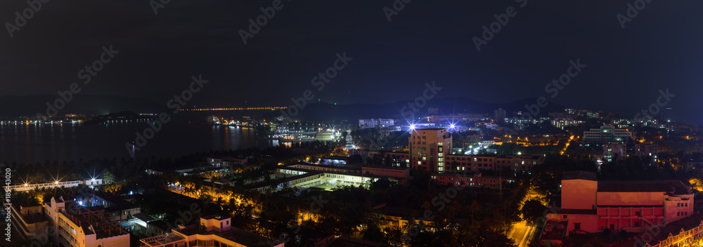 Night panoramic landscape of Dadunhai Bay and the streets next to it in Sanya City on Hainan Island
