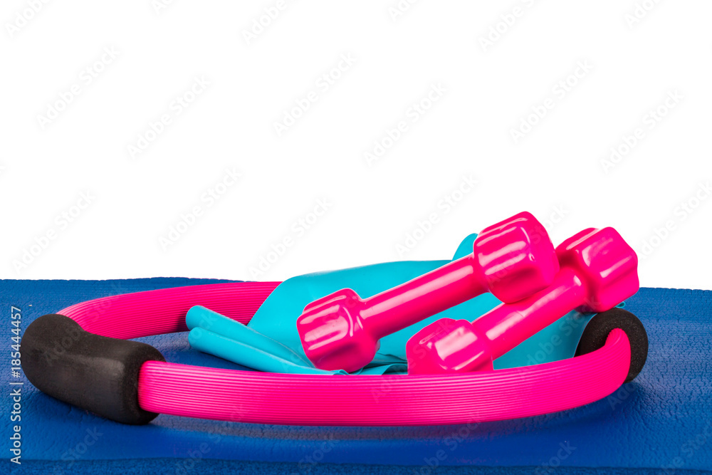Close Up Pilates Circle, Dumbbell, Band on Blue Yoga Mat Close Up Pilates Circle, Dumbbell, Band on Blue Yoga Mat