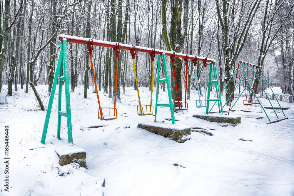 Empty swing in winter time with snow Empty swing in winter time with snow