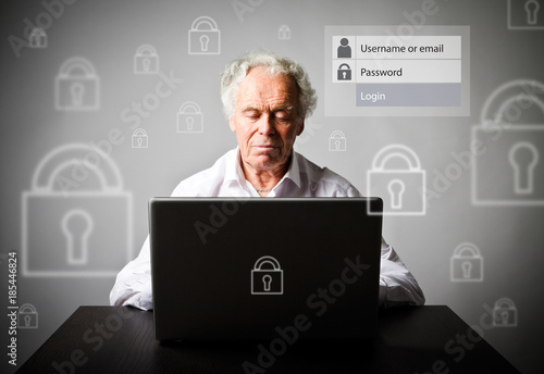 Old man using a laptop. Forgot password concept.