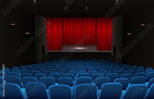 Theater stage with red curtains and blue seats