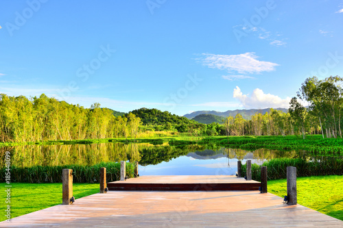 View of wooden bridge water forest mountain natural landscape with blue sky background in Thailand.