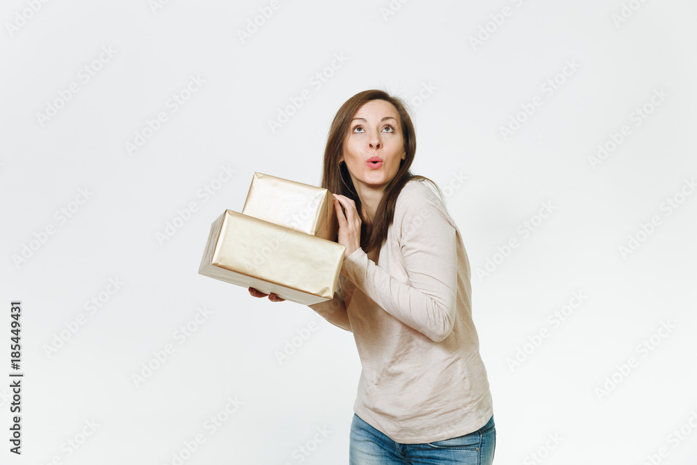 Pretty caucasian fun young happy woman in light clothes with shy charming smile, brown hair and two golden gift boxes with present, celebrating holiday on white background isolated for advertisement. Pretty caucasian fun young happy woman in light clothes with shy charming smile, brown hair and two golden gift boxes with present, celebrating holiday on white background isolated for advertisement.