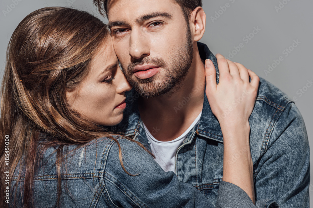 Obraz premium close-up portrait of seductive young couple hugging isolated on grey