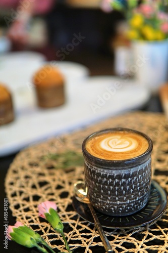 A cup of hot coffee with tulip pattern on black counter