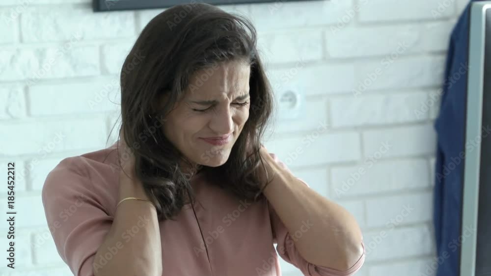 Young businesswoman having neck pain while working on PC computer in office
Young businesswoman having neck pain while working on PC computer in office