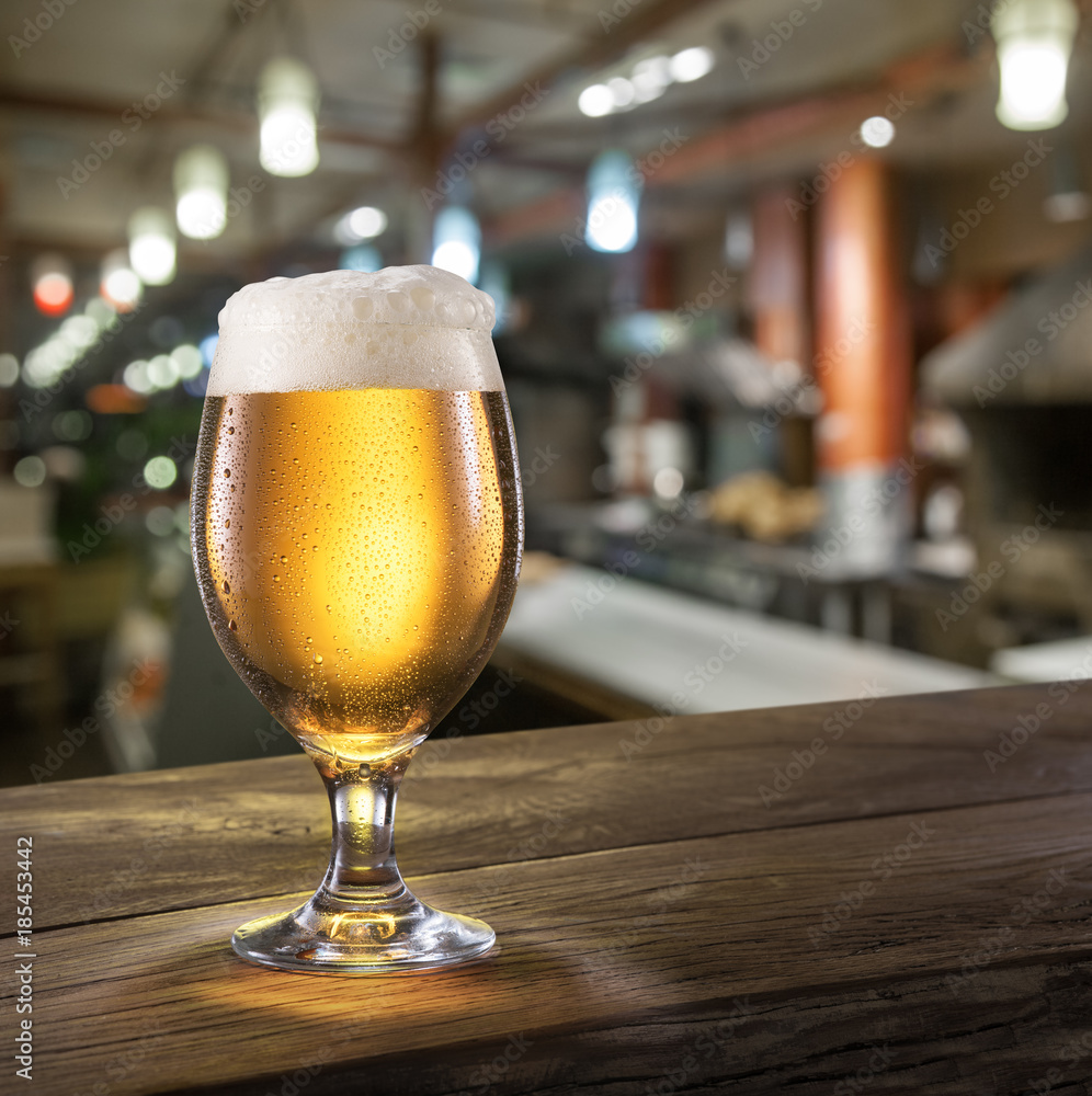 Frosty glass of light beer on the bar counter. Frosty glass of light beer on the bar counter.