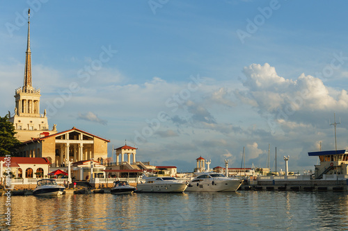 a few small boats and yachts in the Harbor of the seaport of Sochi on a background marine station