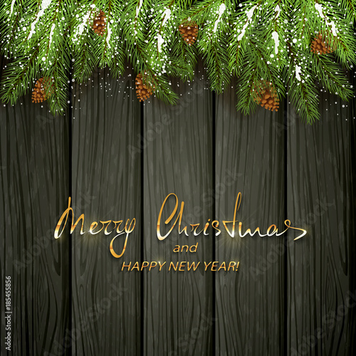 Christmas decorations with fir tree branches and snow on black wooden background