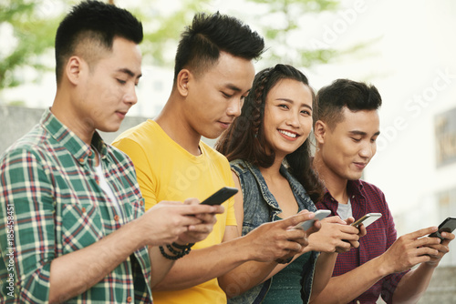 Cheerful young people with smartphones