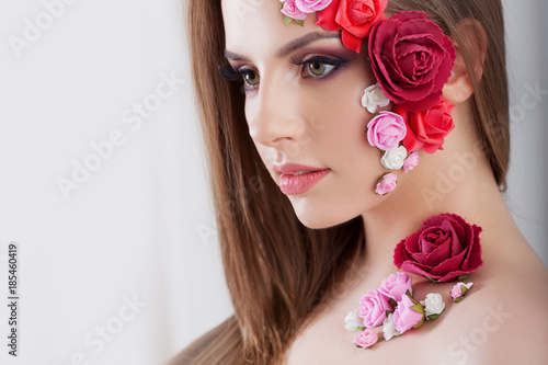 Beautiful young girl with applique flowers on the face.