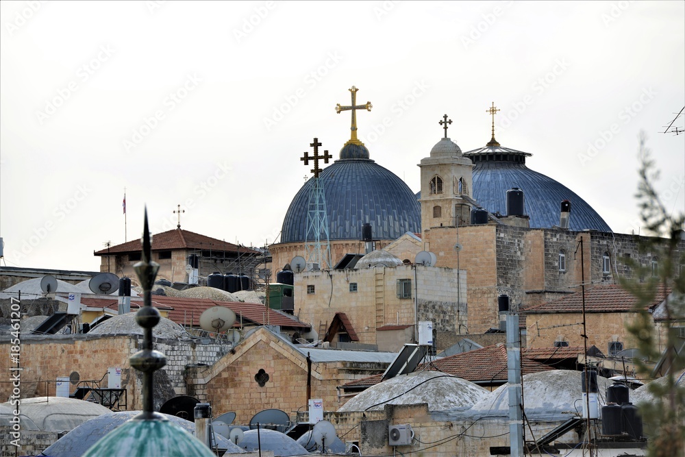 roofs of the old city in jerusalem with church and cross up hill