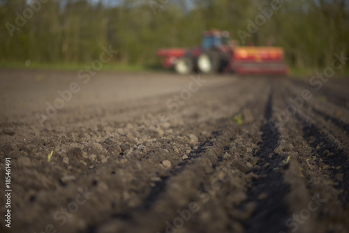 Red tractor with sowing machine on a ploughed field