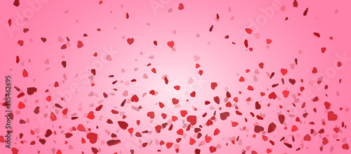 Heart confetti of Valentines petals falling on pink background. Flower petal in shape of heart confetti for Women's Day