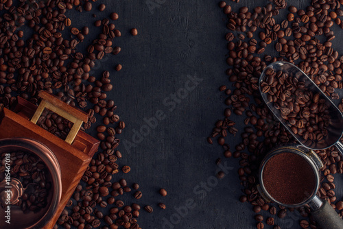top view of roasted coffee beans, coffee grinder and scoop on black © LIGHTFIELD STUDIOS