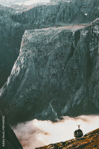 Bild auf Leinwand Scale showing Landscape Man on boulder raised hands and rocky mountains Travel L