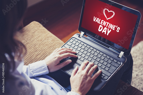 Woman using a laptop to buy Valentine's day gifts on the internet.
