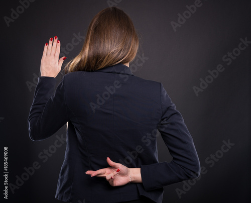 Businesswoman with crossed fingers behind her back