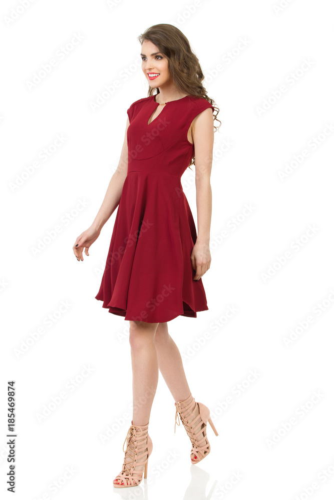 Smiling Beautiful Woman In Red Dress And High Heels Is Walking Smiling Beautiful Woman In Red Dress And High Heels Is Walking