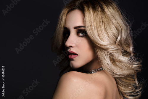 Studio beauty portrait of gorgeous blonde woman on black background