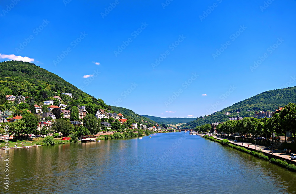 Obraz premium Panoramic view of Neckar river with the old bridge (Karl Theodor Bridge), on the background in Heidelberg, Germany, on a summer sunny day