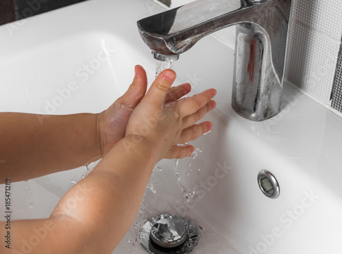 Маленький ребенок моет руки