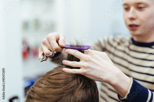 hairdresser in the beauty salon does a haircut
