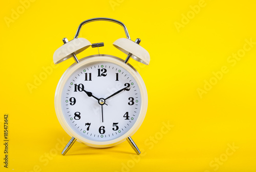 Old clock on yellow background and space for text