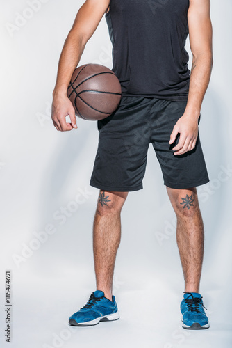 cropped image of basketball player standing with ball