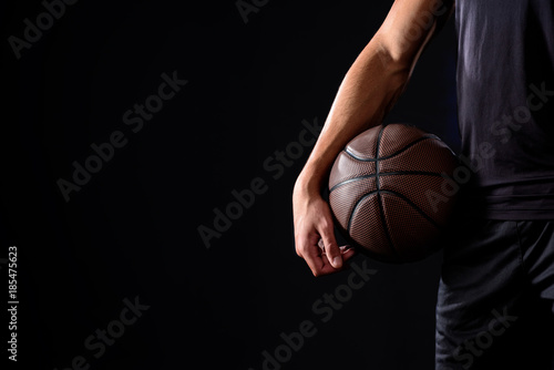 cropped shot of basketball player with ball isolated on black © LIGHTFIELD STUDIOS