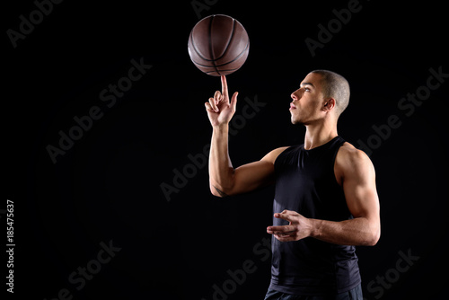 young african american basketball player spinning ball on finger isolated on black