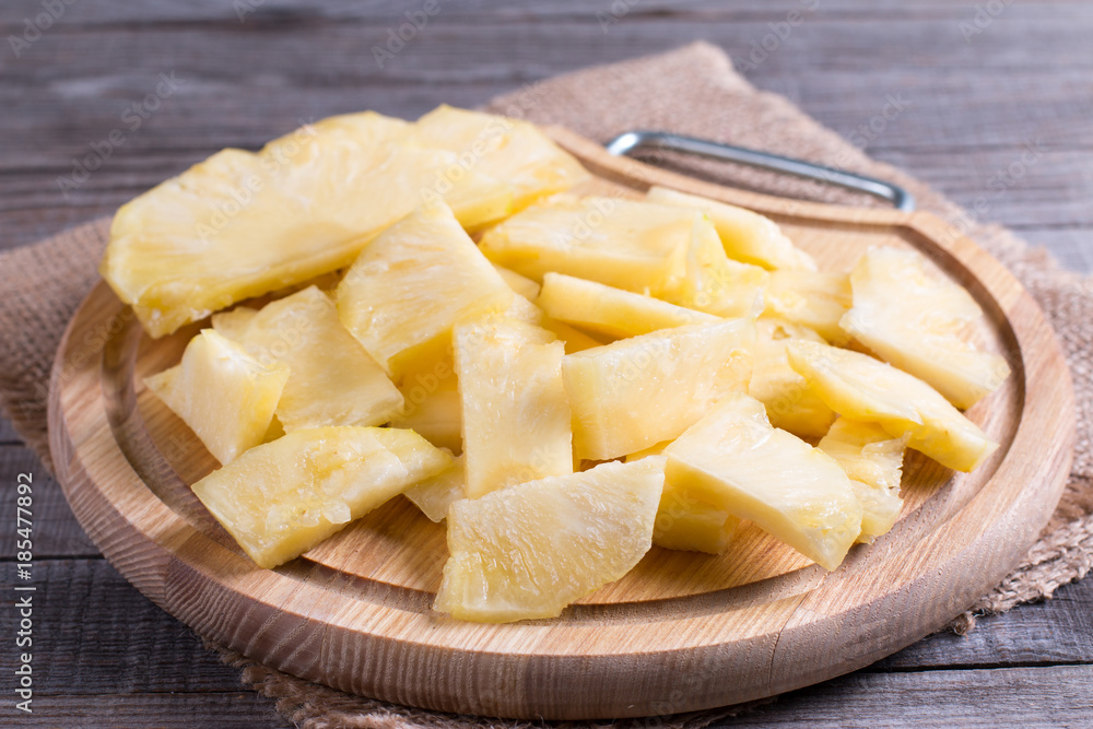 Piece of pineapple on a cutting board on the table Piece of pineapple on a cutting board on the table