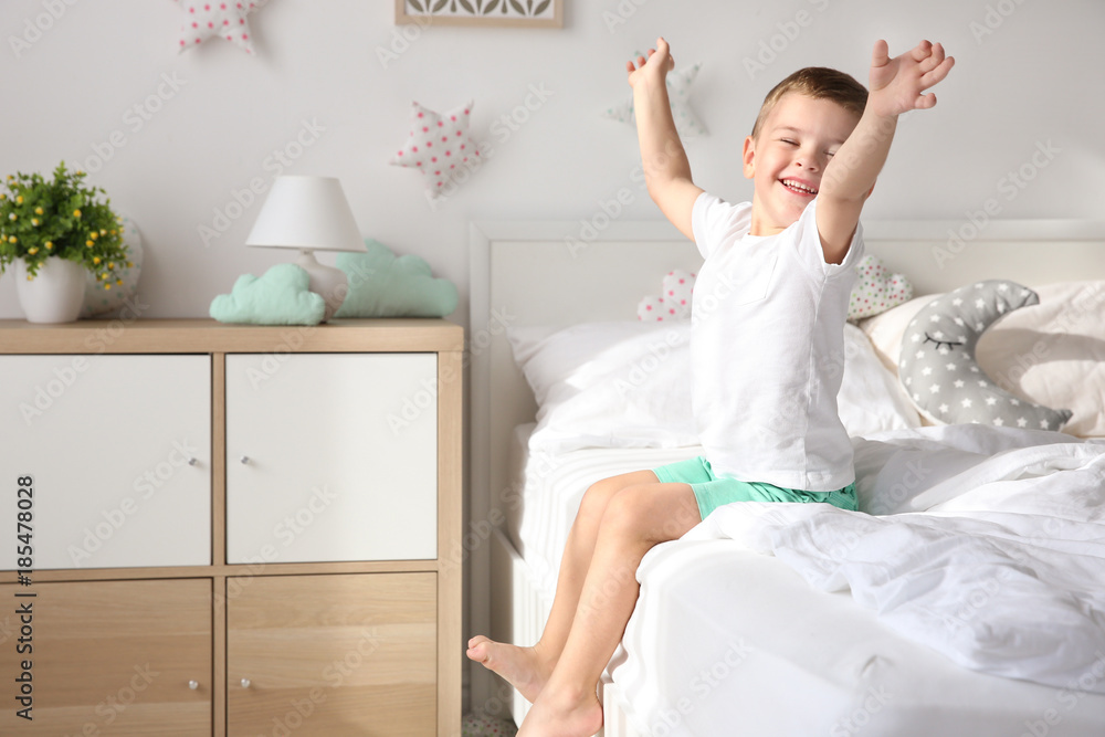 Cute little boy on bed at home