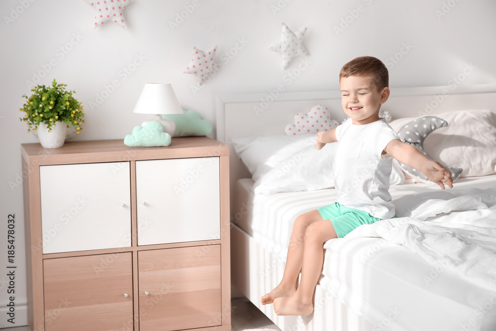 Cute little boy on bed at home