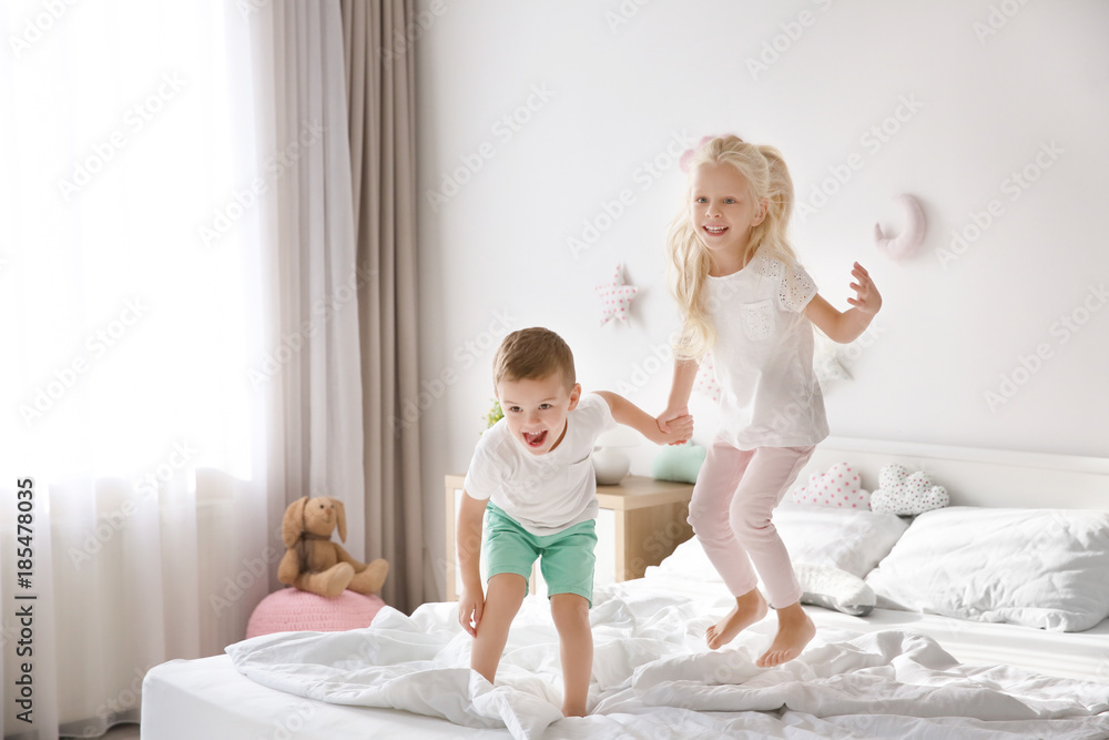 Cute little children jumping on bed at home Cute little children jumping on bed at home