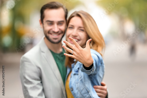 Fotografie Young man with his beloved showing engagement ring outdoors