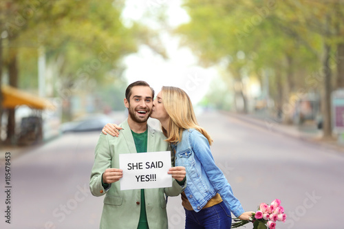Young man holding paper wit...
