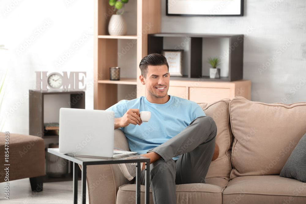 Handsome man drinking coffee while resting on sofa at home Handsome man drinking coffee while resting on sofa at home