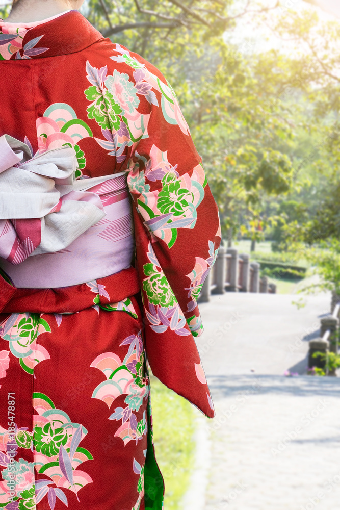 Young woman wearing kimono traditional Japan walking in the garden Young woman wearing kimono traditional Japan walking in the garden