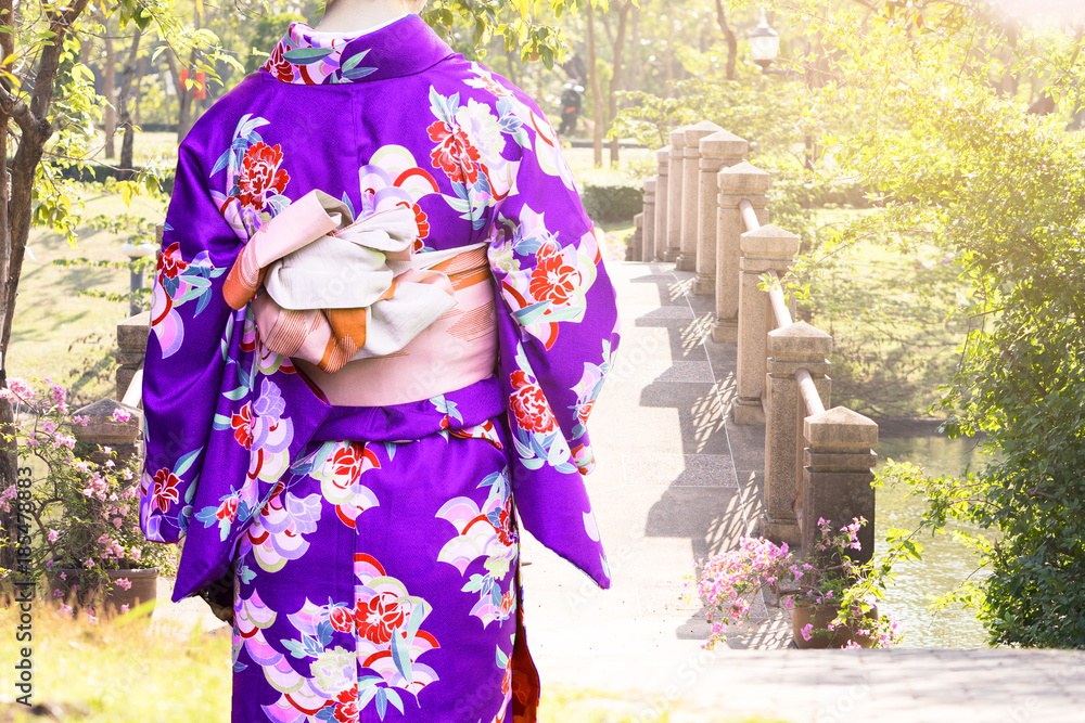 Young woman wearing kimono traditional Japan walking in the garden